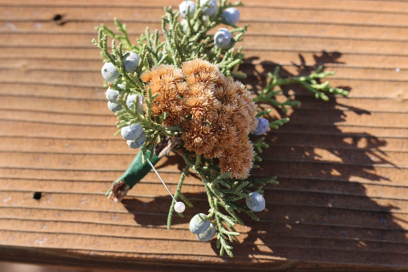boutonniere with dried yarrow and evergreen branches 
