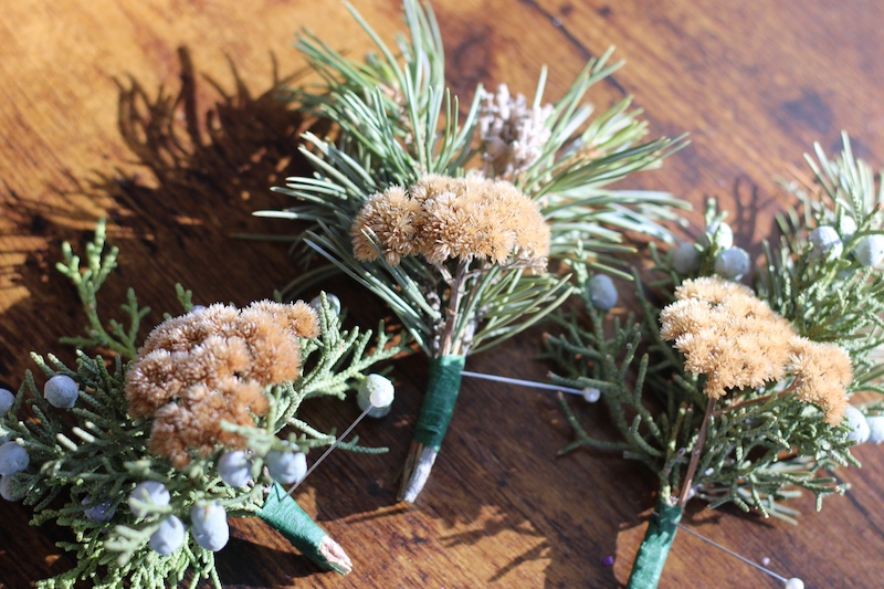 3 boutonniere with dried flowers and evergreen branches